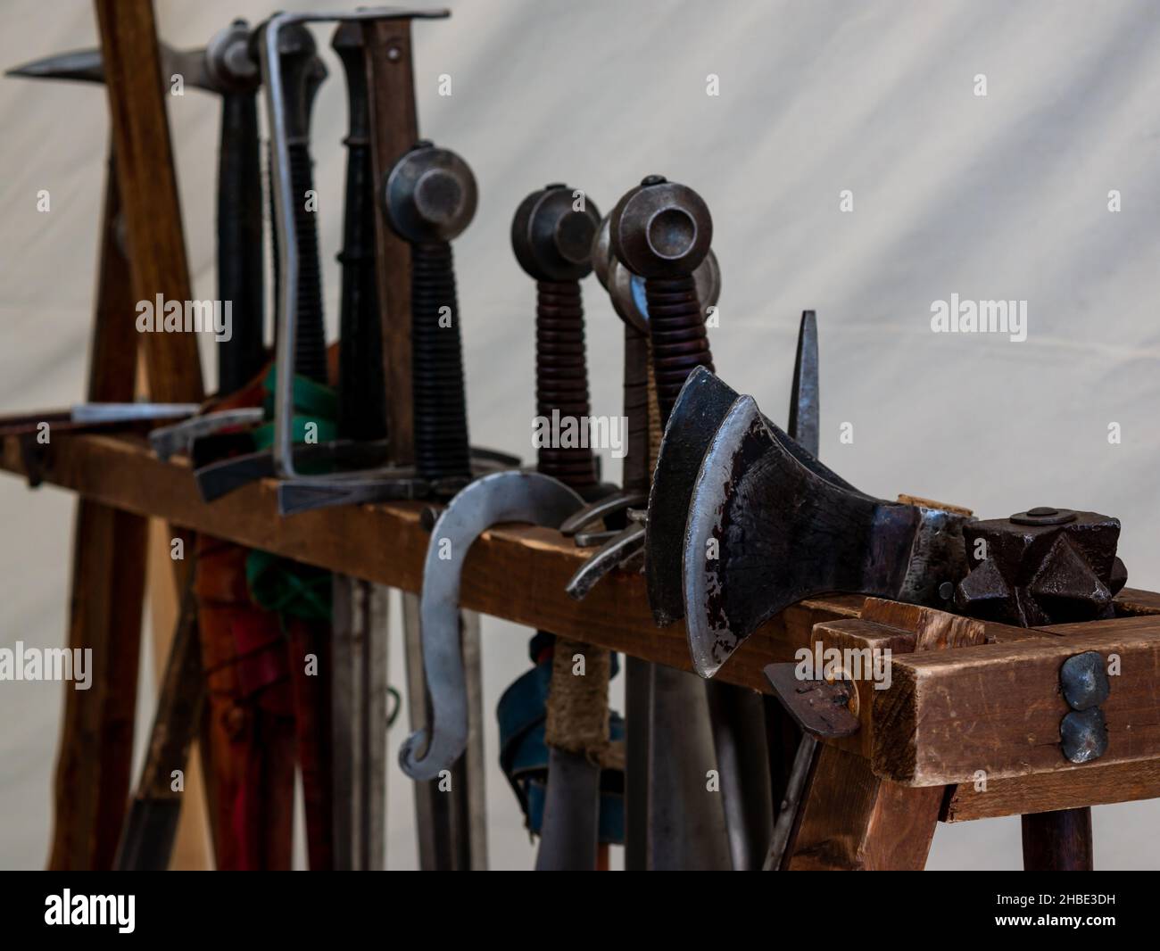 various medieval weapons on a wooden rack Stock Photo