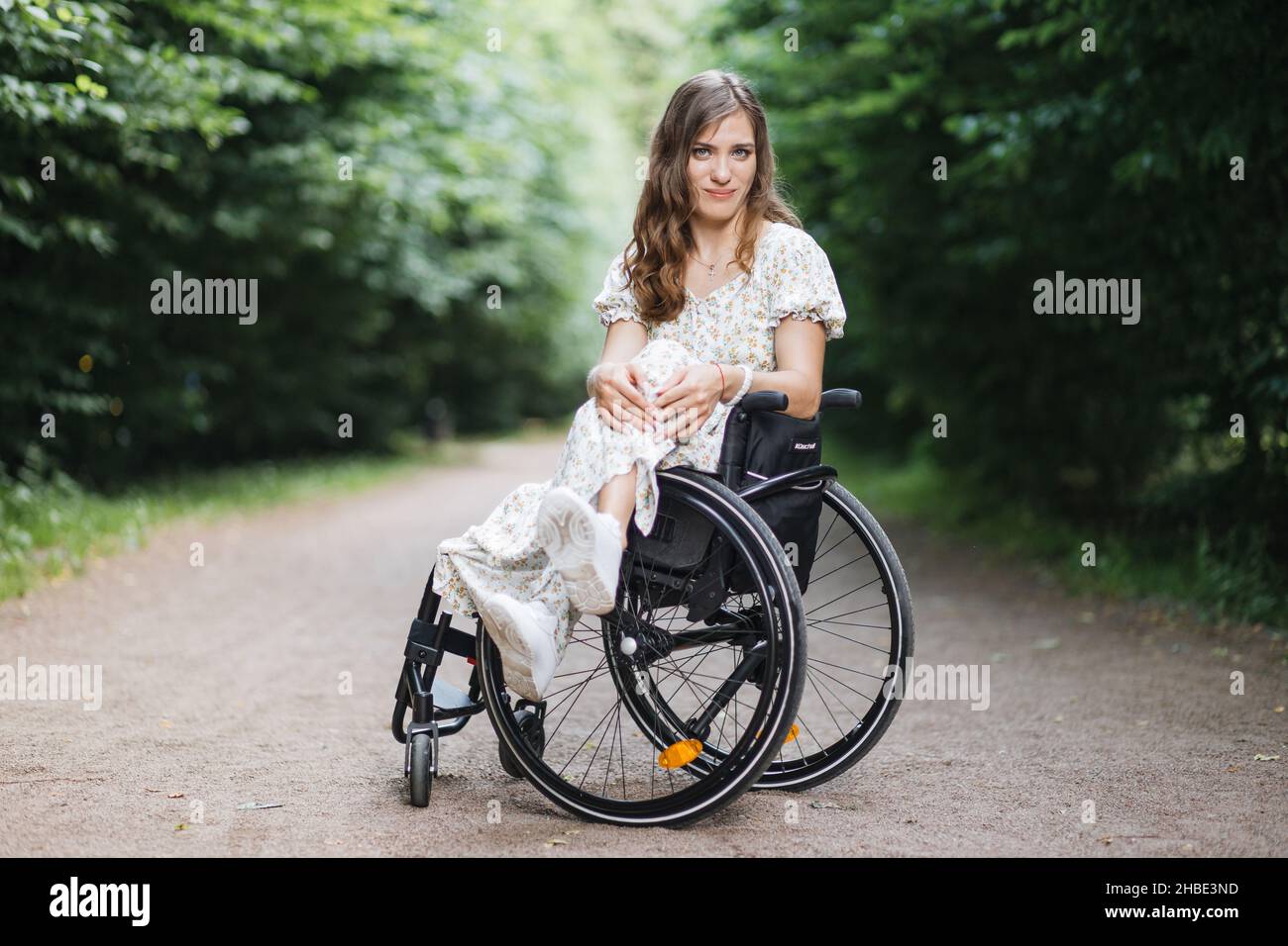 Beautiful woman who using wheelchair looking at camera while sitting ...