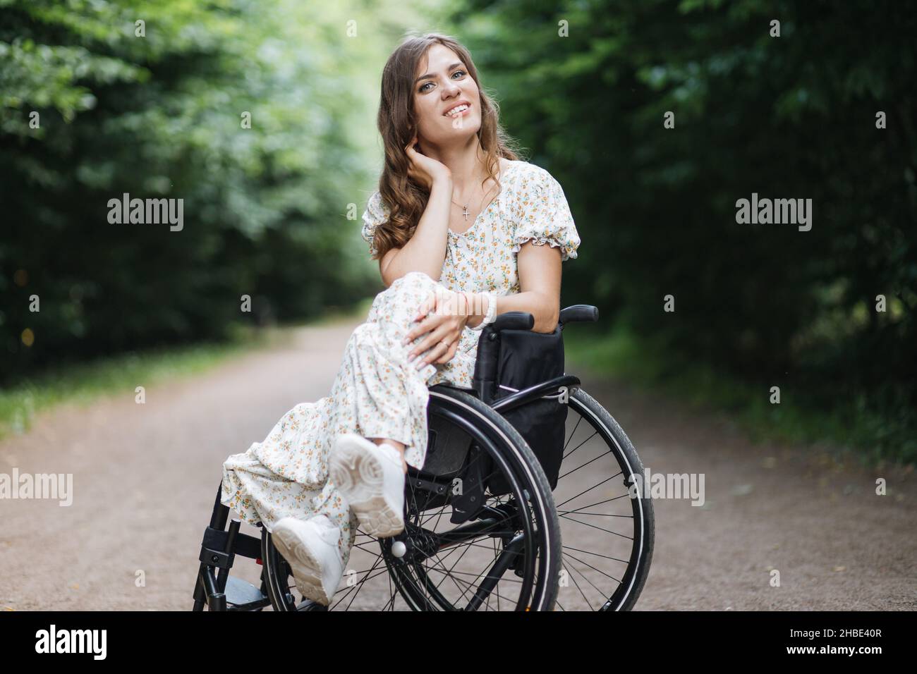 Beautiful woman who using wheelchair looking at camera while sitting ...