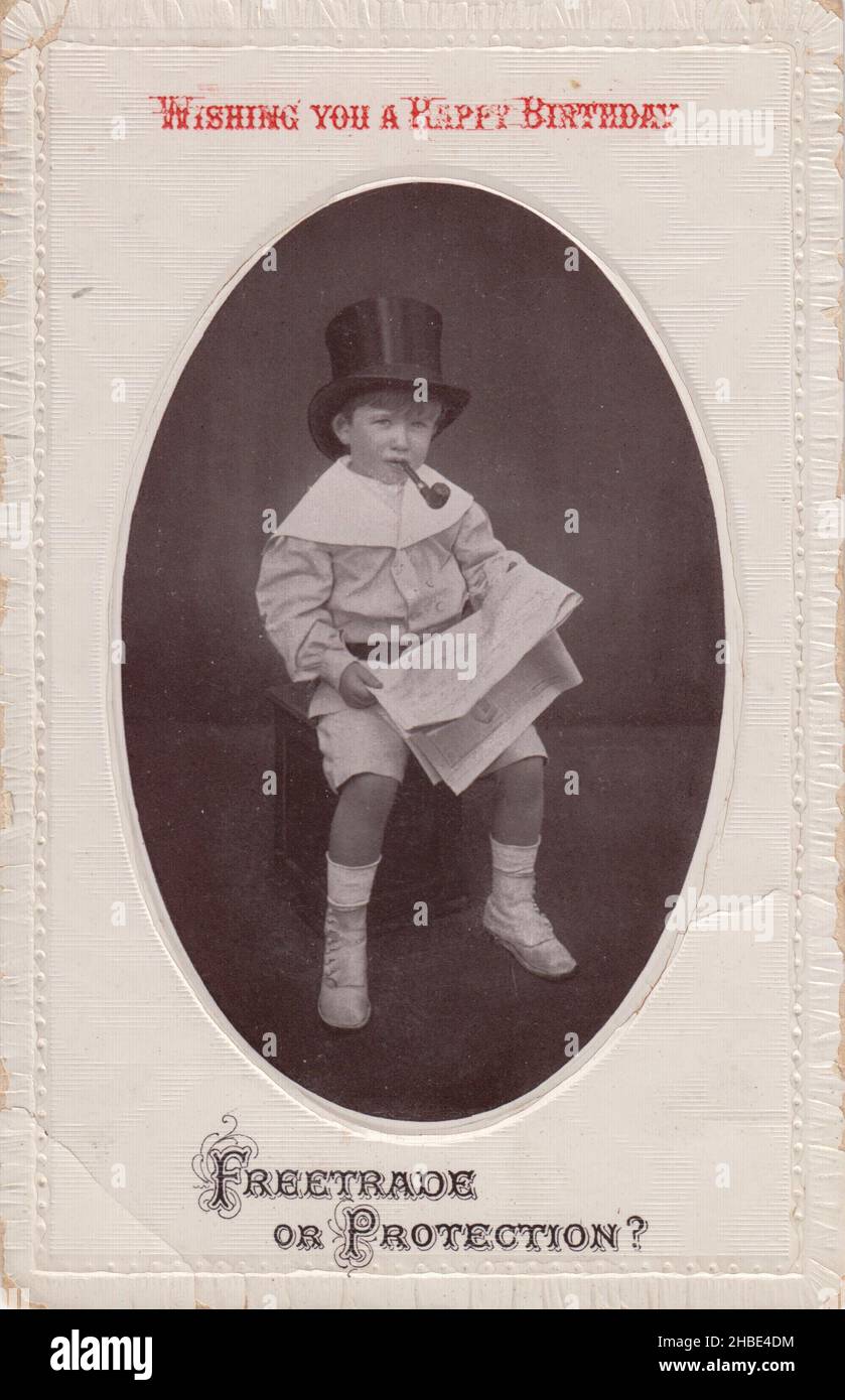'Wishing you a Happy Birthday. Freetrade or Protection?' A not especially celebratory birthday postcard, featuring a photograph of a small boy with a top hat, pipe and newspaper, and a reference to one of the more divisive political / economic arguments of the early 20th century Stock Photo