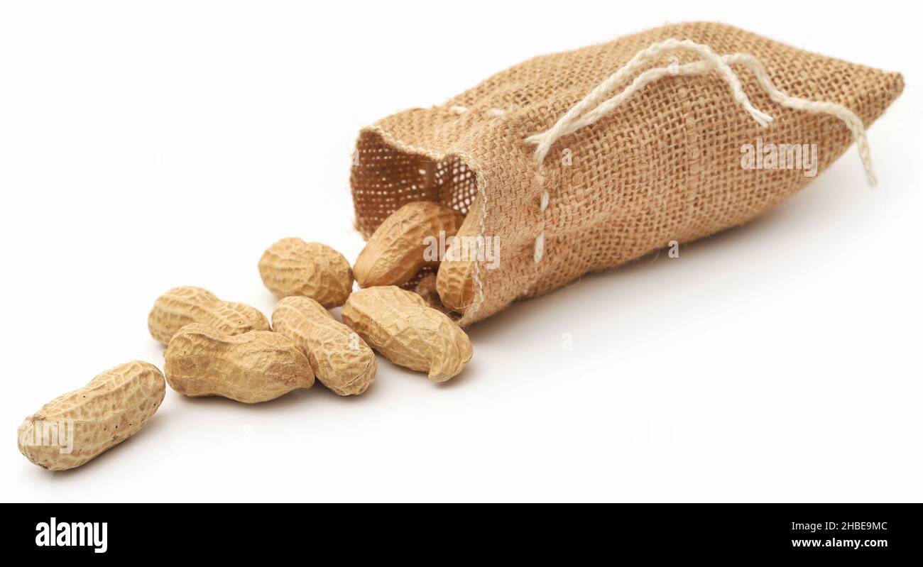 Fresh Peanuts in sack over white background Stock Photo