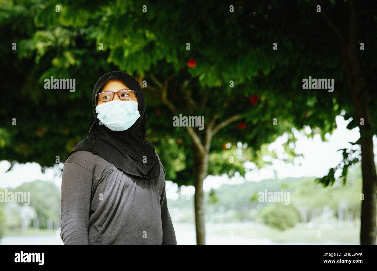 Portrait of young muslim woman wearing glasses and hijab head scarf ...