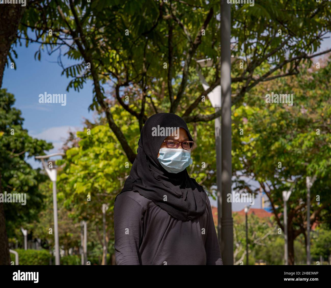 Portrait of young muslim woman wearing glasses and hijab head scarf ...
