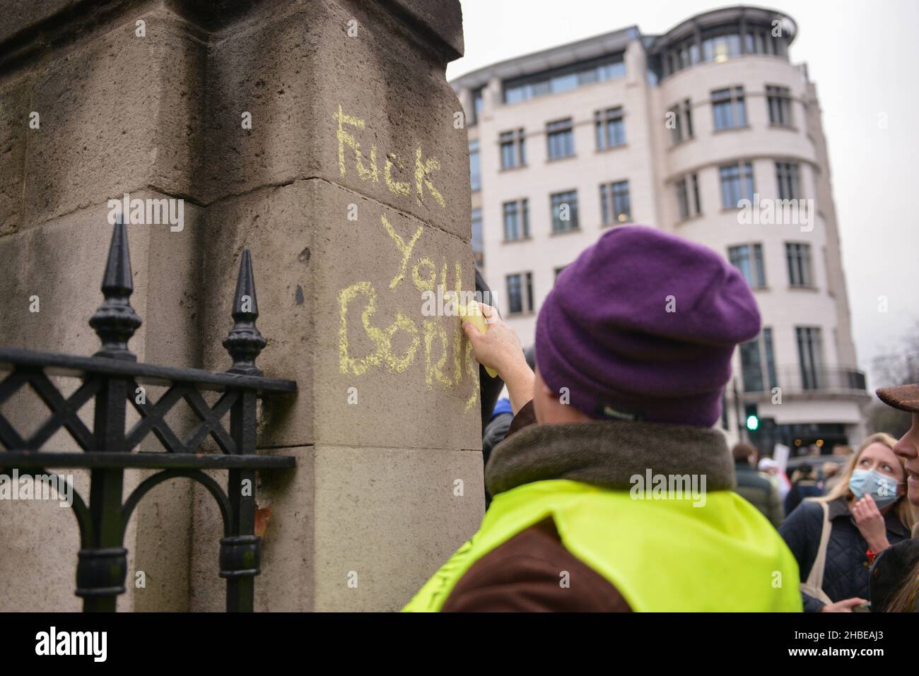 A protester writes on the wall an anti Boris Johnson slogan, during the demonstration. Anti vaccine and anti vaccine pass protesters joined by opponents of Covid 19 restrictions, gathered at Parliament Square and marched through central London. Stock Photo
