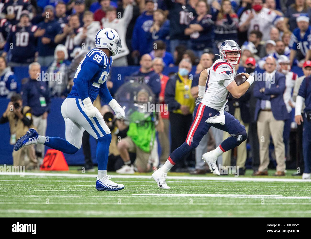 Indianapolis, Indiana, USA. 18th Dec, 2021. New England Patriots quarterback Mac Jones (10) runs with the ball as Indianapolis Colts defensive lineman DeForest Buckner (99) pursues during NFL football game action between the New England Patriots and the Indianapolis Colts at Lucas Oil Stadium in Indianapolis, Indiana. Indianapolis defeated New England 27-17. John Mersits/CSM/Alamy Live News Stock Photo