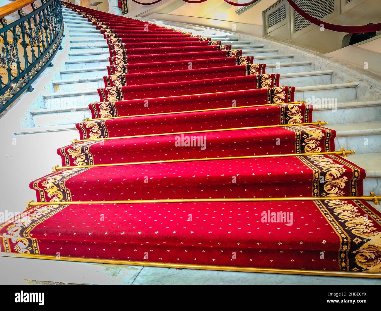 Beautiful curved staircase with red carpet for guests Stock Photo Alamy