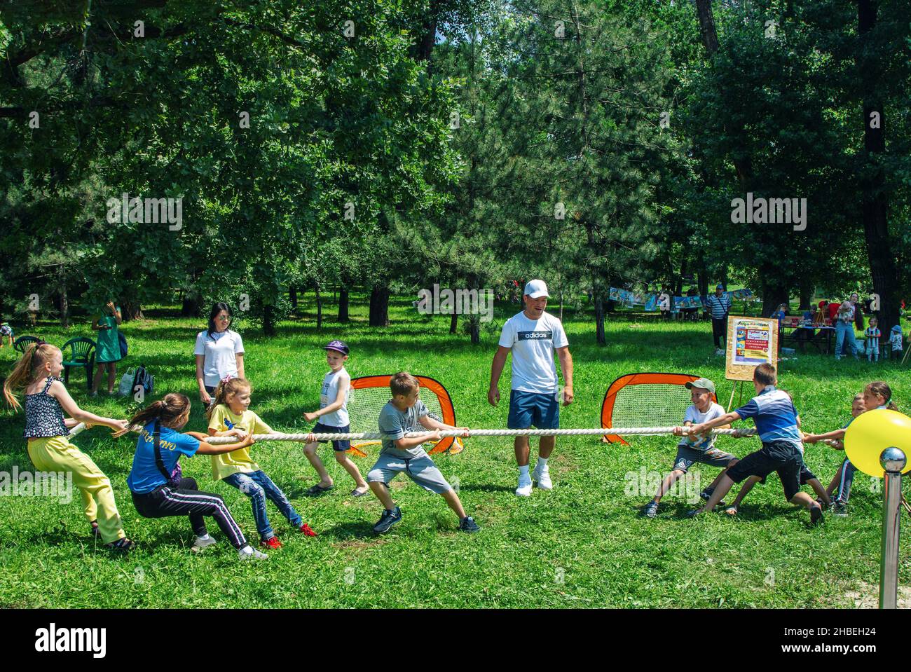 Zaporizhia, Ukraine- June 19, 2021: charity family festival - children- boys and girls - having fun, competing in tug of war game, on a meadow in a ci Stock Photo
