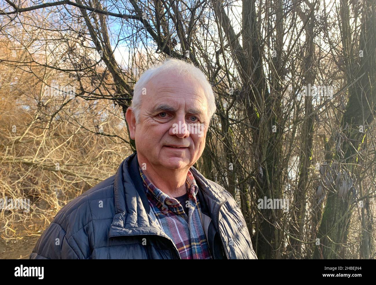 Portrait of a man wearing a puffer jacket standing in rural landscape, British Columbia, Canada Stock Photo