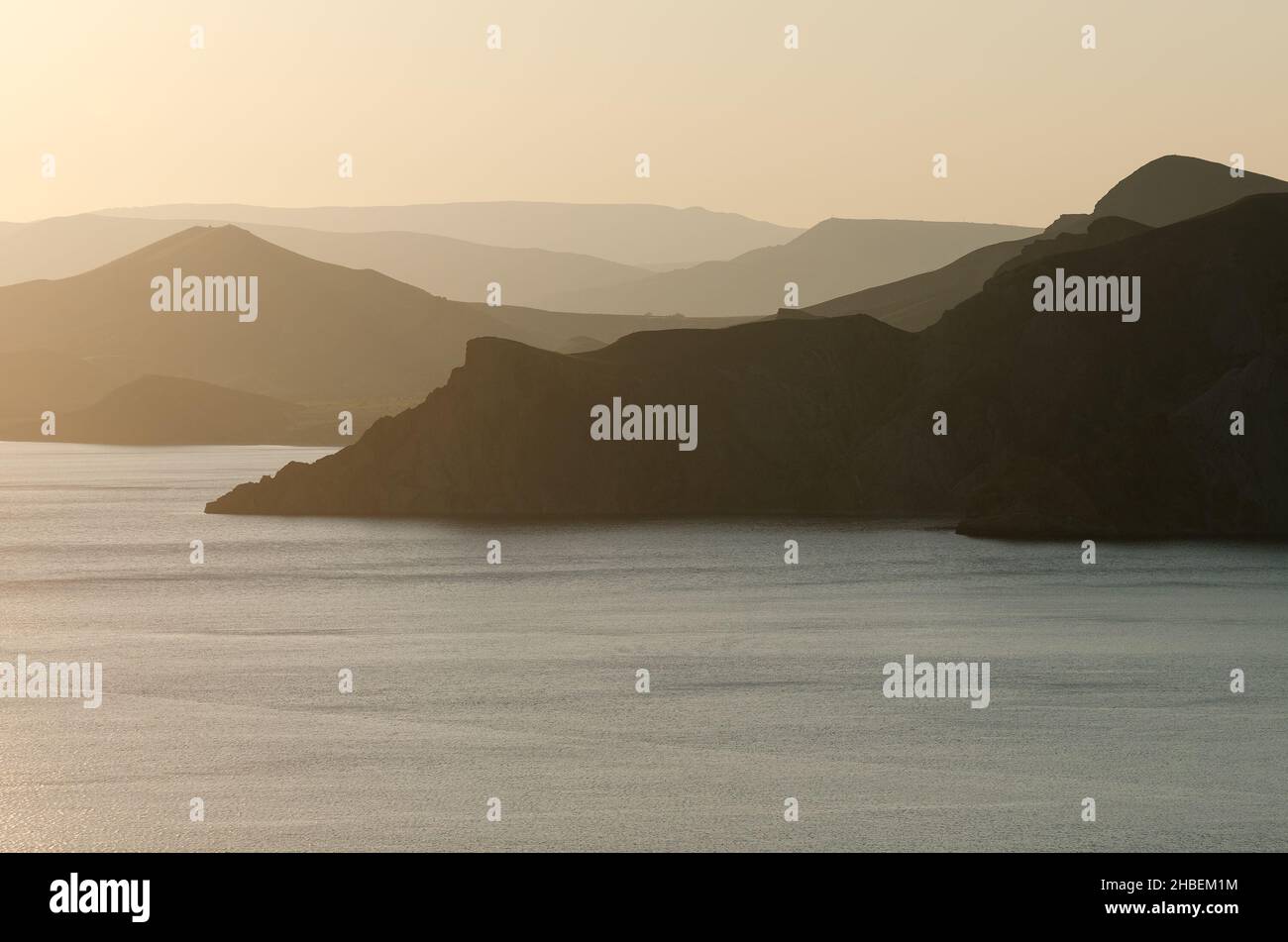 Seascape with a panoramic view of the mountains. Sunset in yellow ...