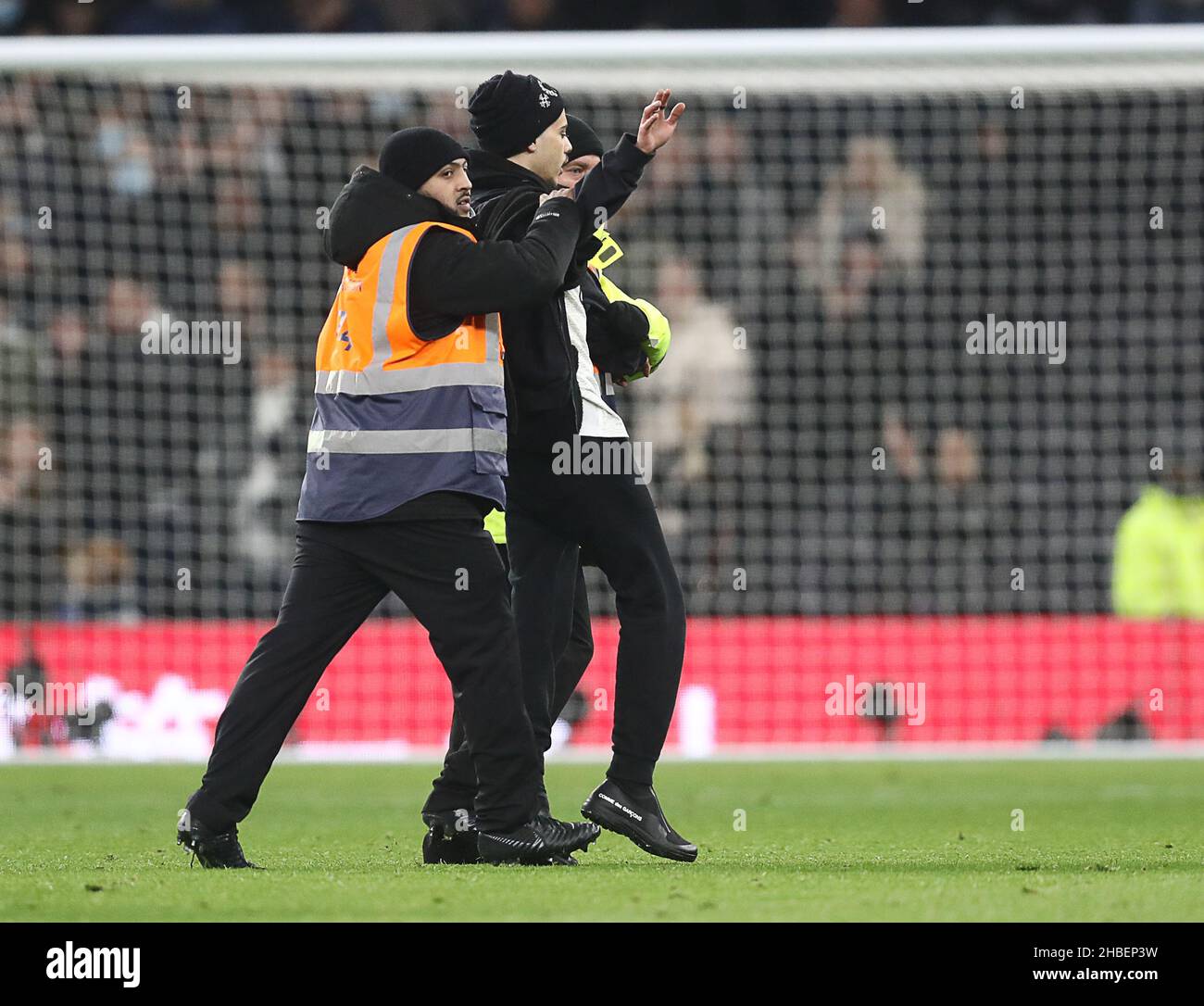 London, England, 19th December 2021. A fan runs who runs onto he pitch is taken off by stewards during the Premier League match at the Tottenham Hotspur Stadium, London. Picture credit should read: Paul Terry / Sportimage Stock Photo