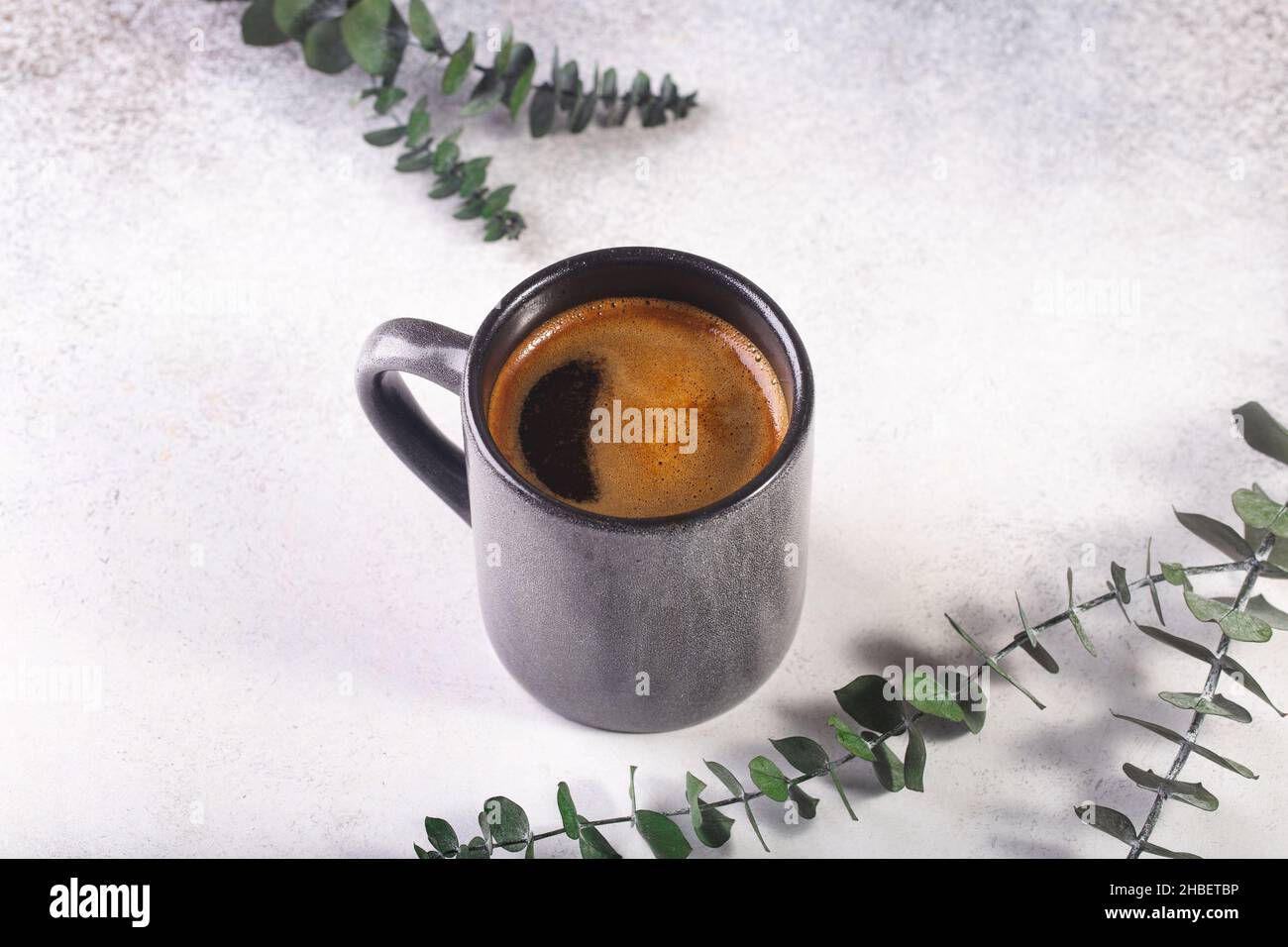 cup of coffee on grey table eucalyptus leaves Stock Photo