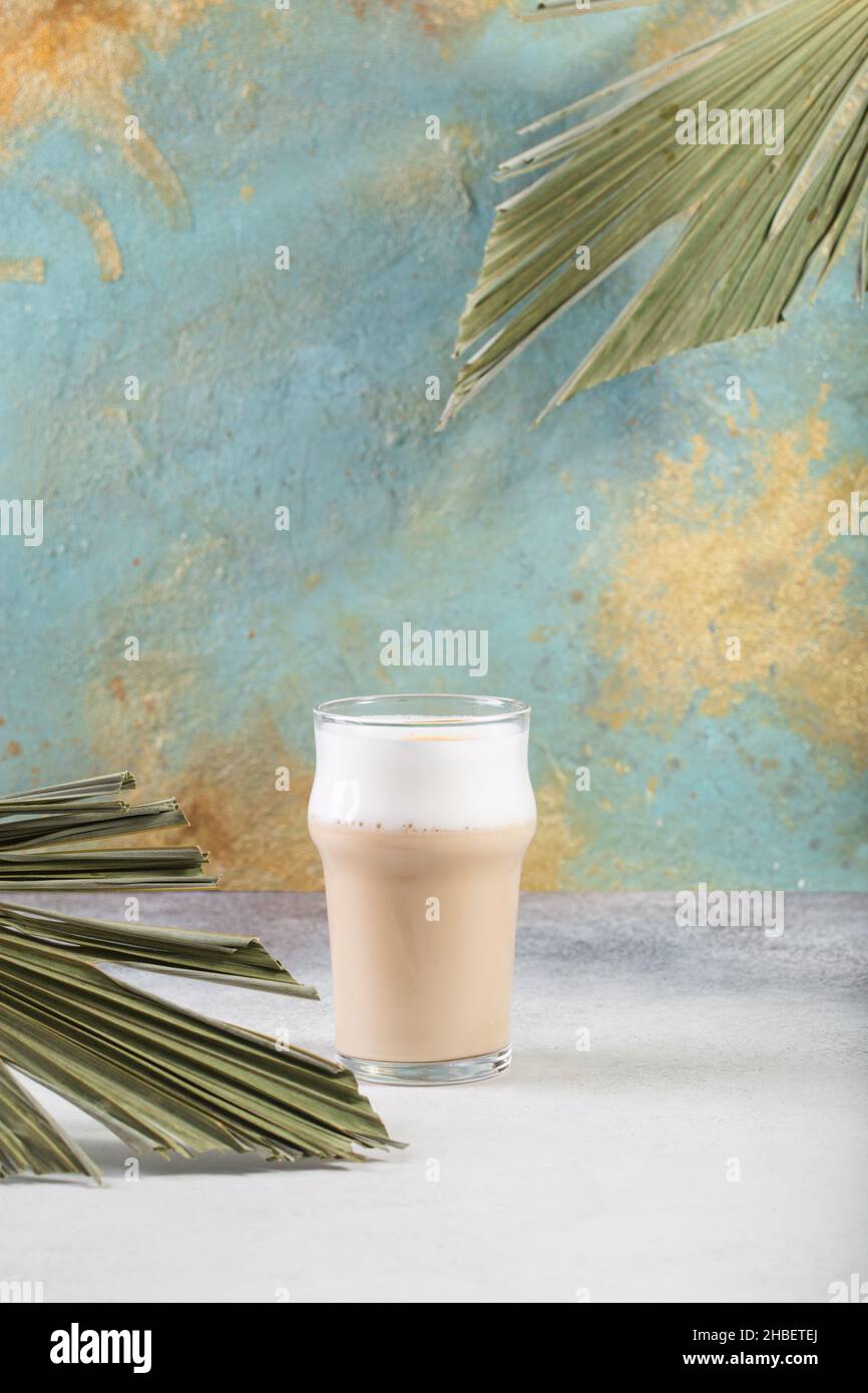 Cafe Latte On The Concrete Table palm tree leaves Stock Photo