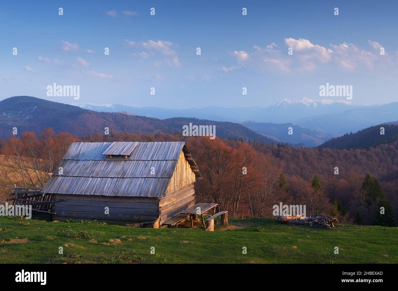 Spring landscape. Old wooden house in mountains. Sunny evening. Village of shepherds. Carpathians, Ukraine, Europe Stock Photo