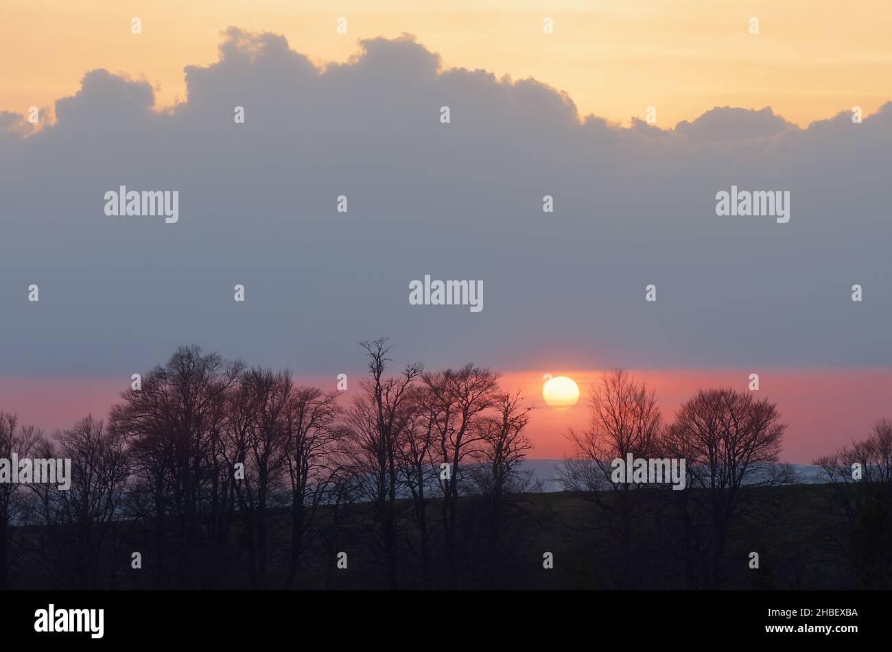 Evening landscape with the setting sun behind the trees. Sunset in the mountains Stock Photo