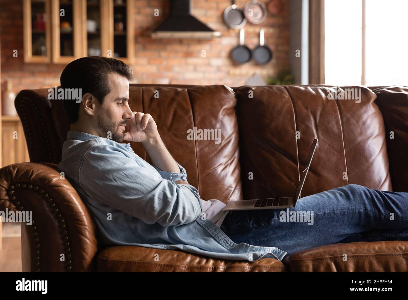 Relaxed young handsome man using computer at home Stock Photo - Alamy