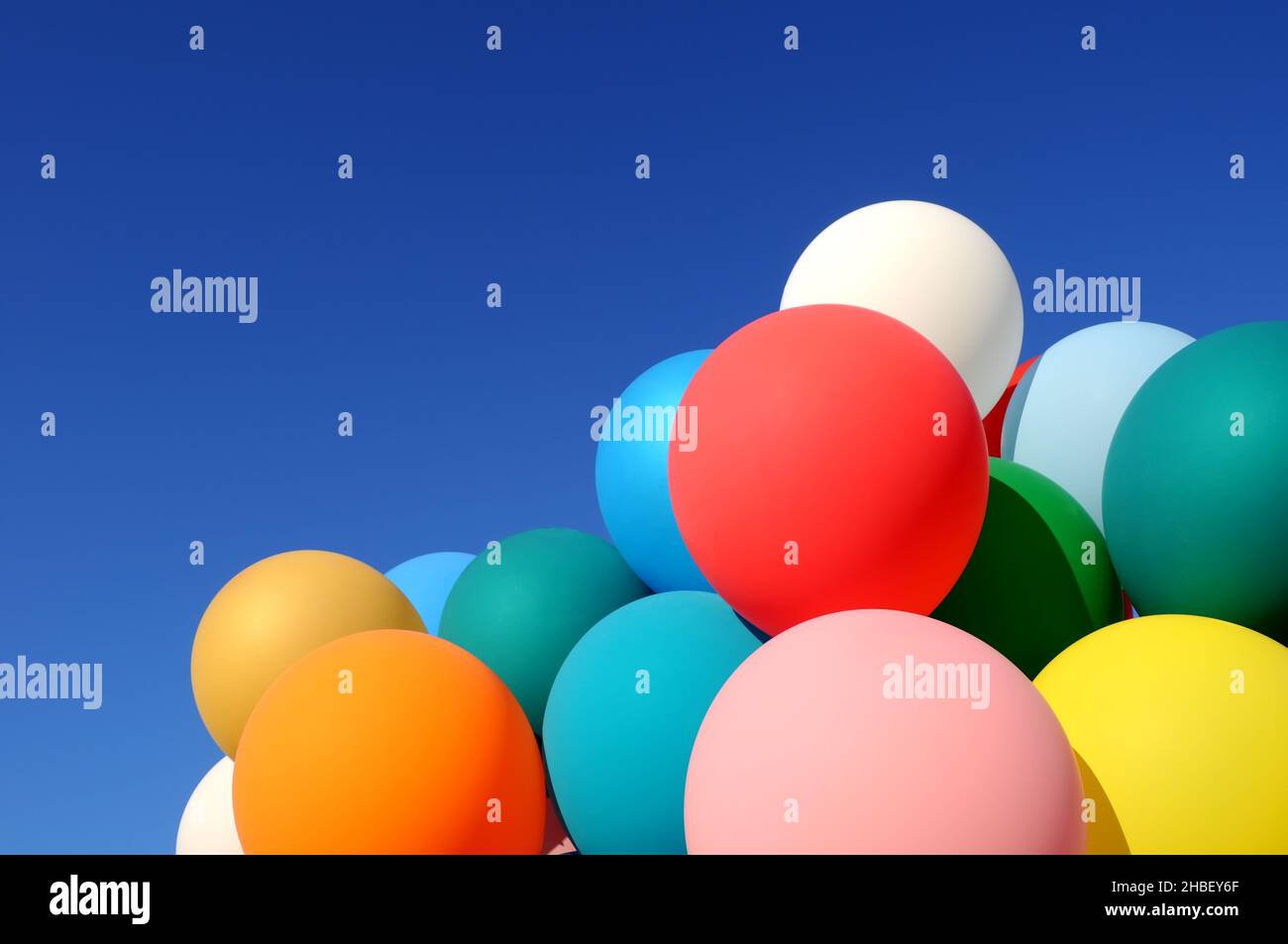 group of multicolored balloons in the city festival on clear blue sky background Stock Photo