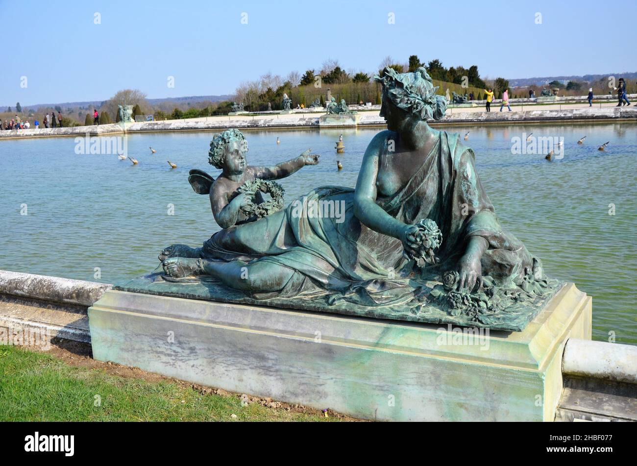 Bronze statue of three cherubs on the edge of a basin of the Bassin du Midi in the gardens of Versailles, in front of the west facade of the Palace of Stock Photo