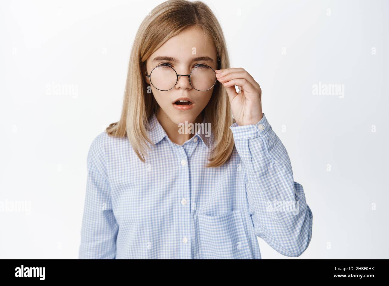 Portrait of blond girl, little kid in glasses squinting, has