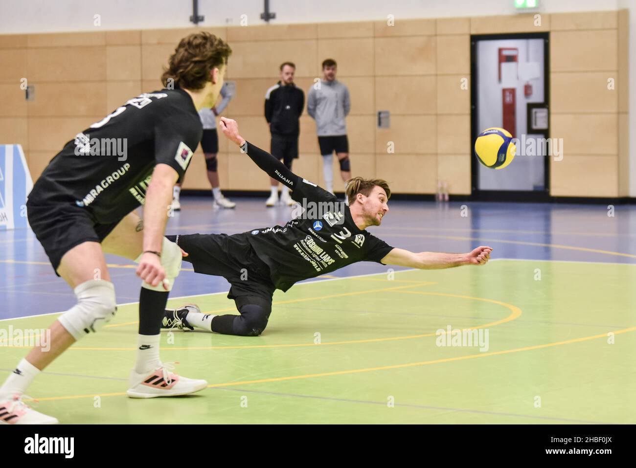 Germany ,Eltmann, Georg Schäfer Halle - 19 Dec 2021 - 3.Liga, Volleyball - VC Eltmann vs TSV Eibelstadt  Image: (fLTR) Ryan Scutter (VC Eltmann, 8) watches as Johannes Engel (VC Eltmann, 3) throws himself to recover a hard spike. Stock Photo