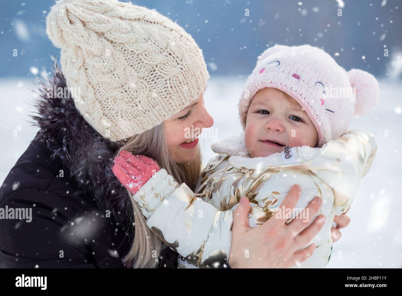 Young mom hugs her little daughter. Winter time, outdoor activity Stock Photo