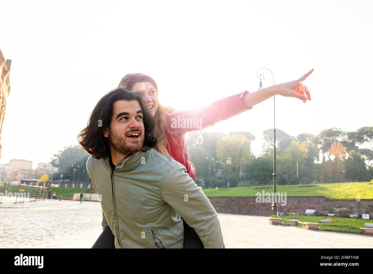 Young Couple Having Fun Traveling In Rome The Man Carries His