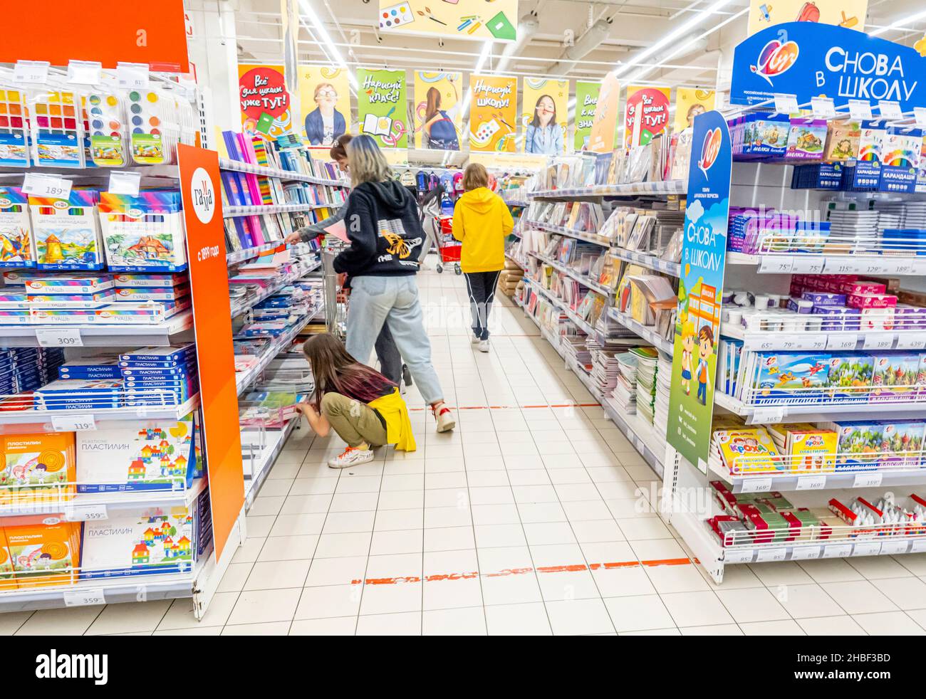 Back view of family buying school products in an aisle in Auchan supermarket, Moscow, Russia Stock Photo
