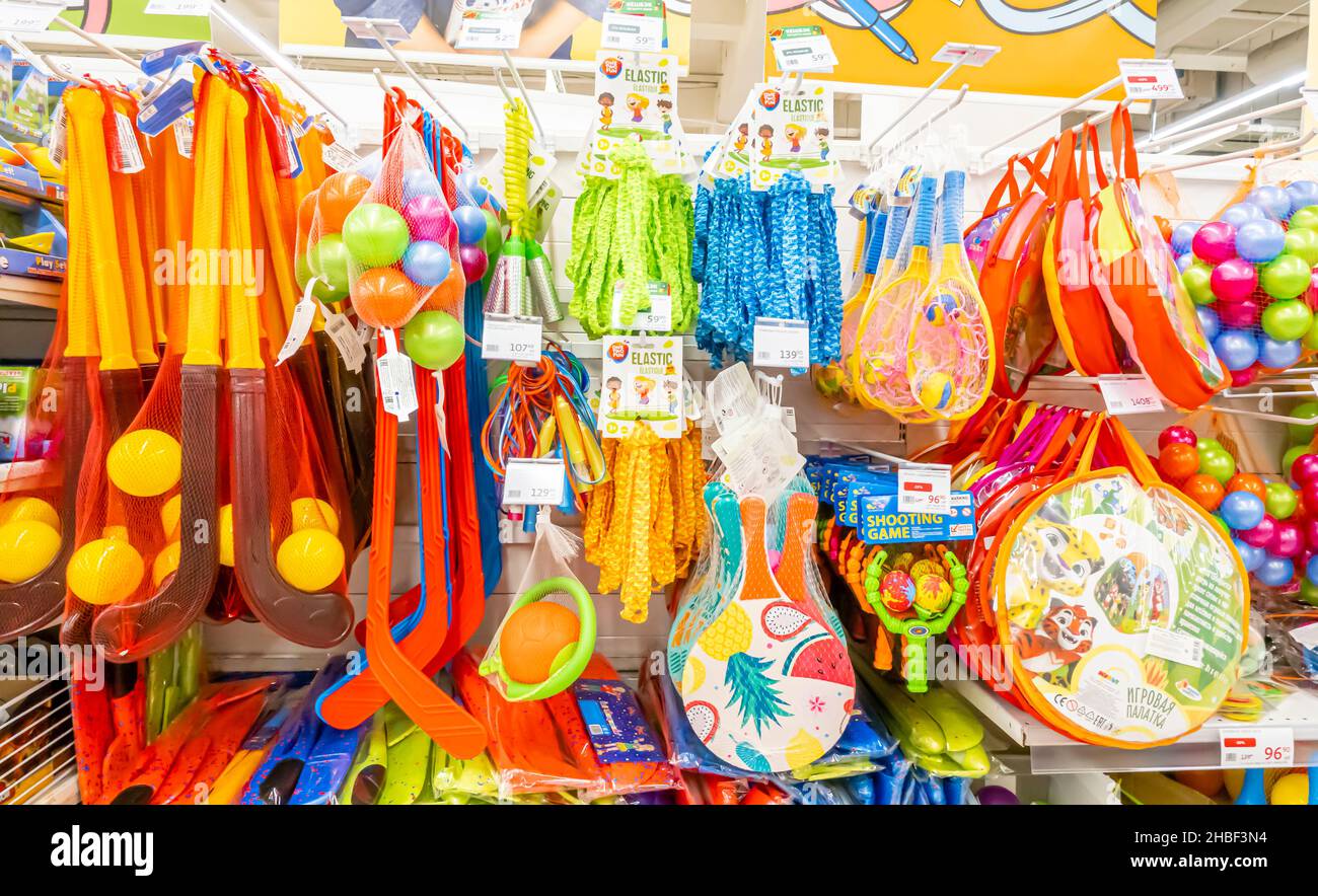 Plastic sports toys- clubs, balls, rackets hanging selling in Auchan store, Moscow Russia Stock Photo