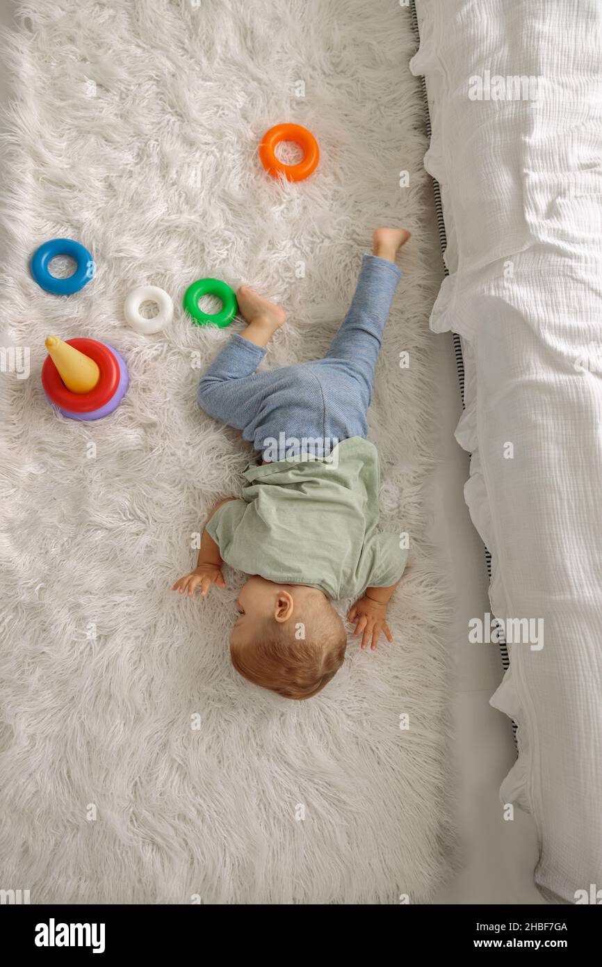 Baby sleeping on the floor among the toys in the bedroom Stock Photo