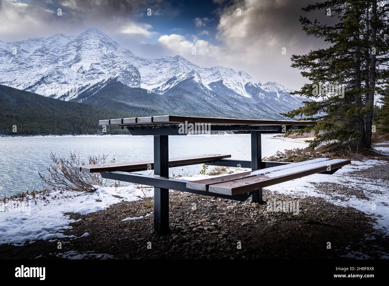 A wooden picnic table overlooking the Spray Lakes in the Canadian Rocky Mountains near Banff. Stock Photo