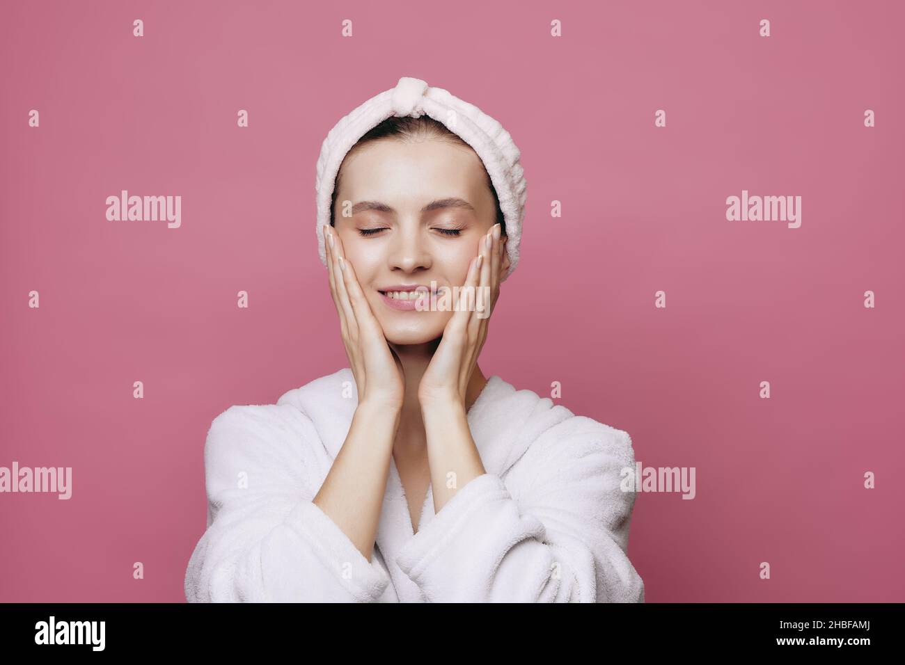 Smiling girl with headband cleansing her face Stock Photo