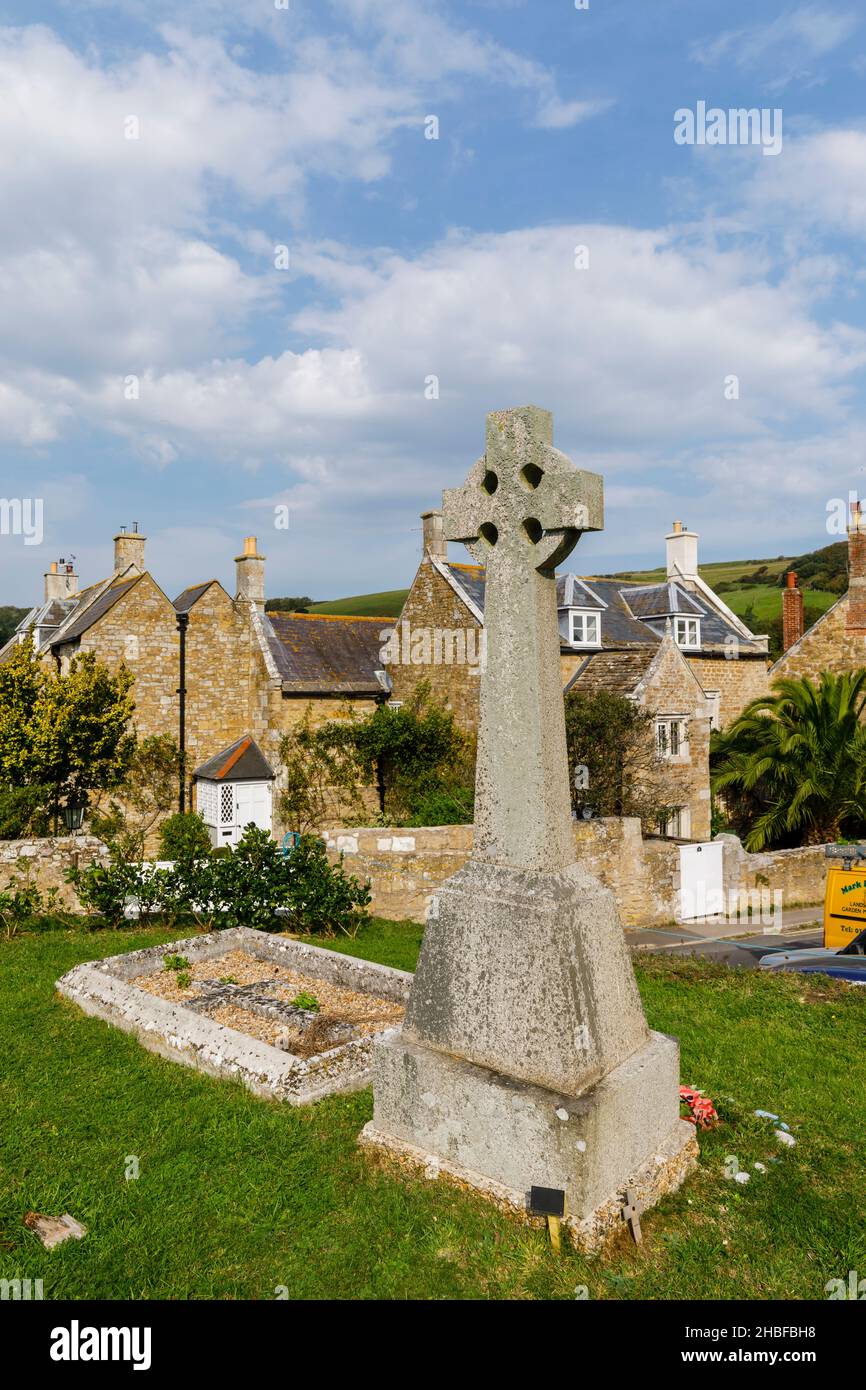 Celtic cross war memorial in the churchyard of the 14th century historic medieval St Nicholas' Church in Abbotsbury, a village in Dorset, SW England Stock Photo