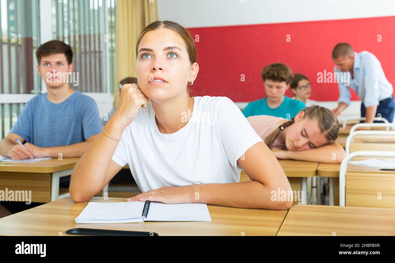 Pupils listening and one girl sleeping Stock Photo