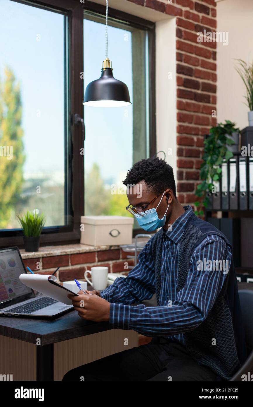 Startup entrepreneur wearing true wireless earbuds and covid protective ...