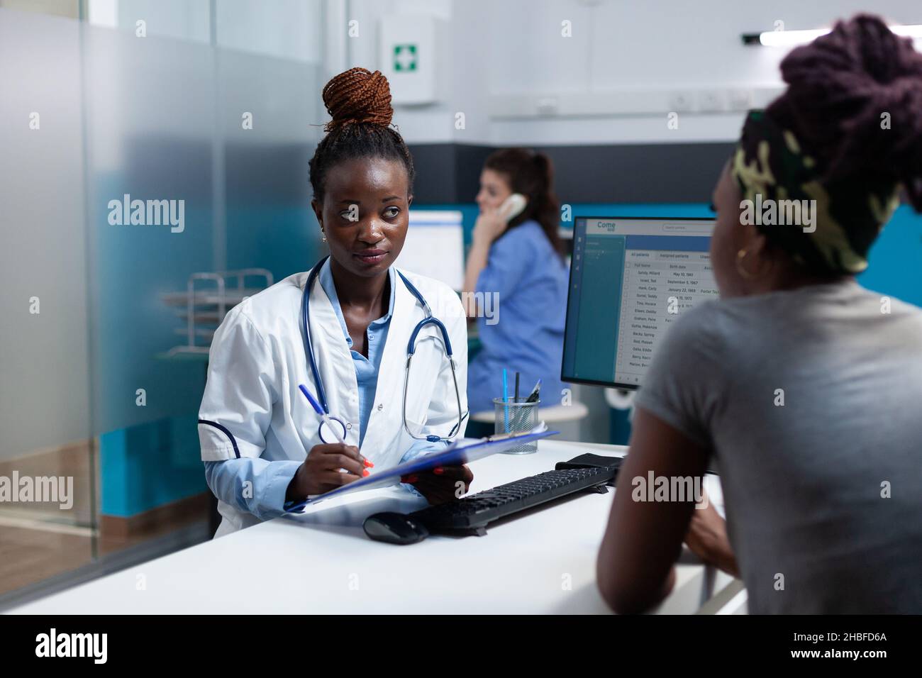 African american therapist discussing sickness symptoms questionnaire with sick patient during