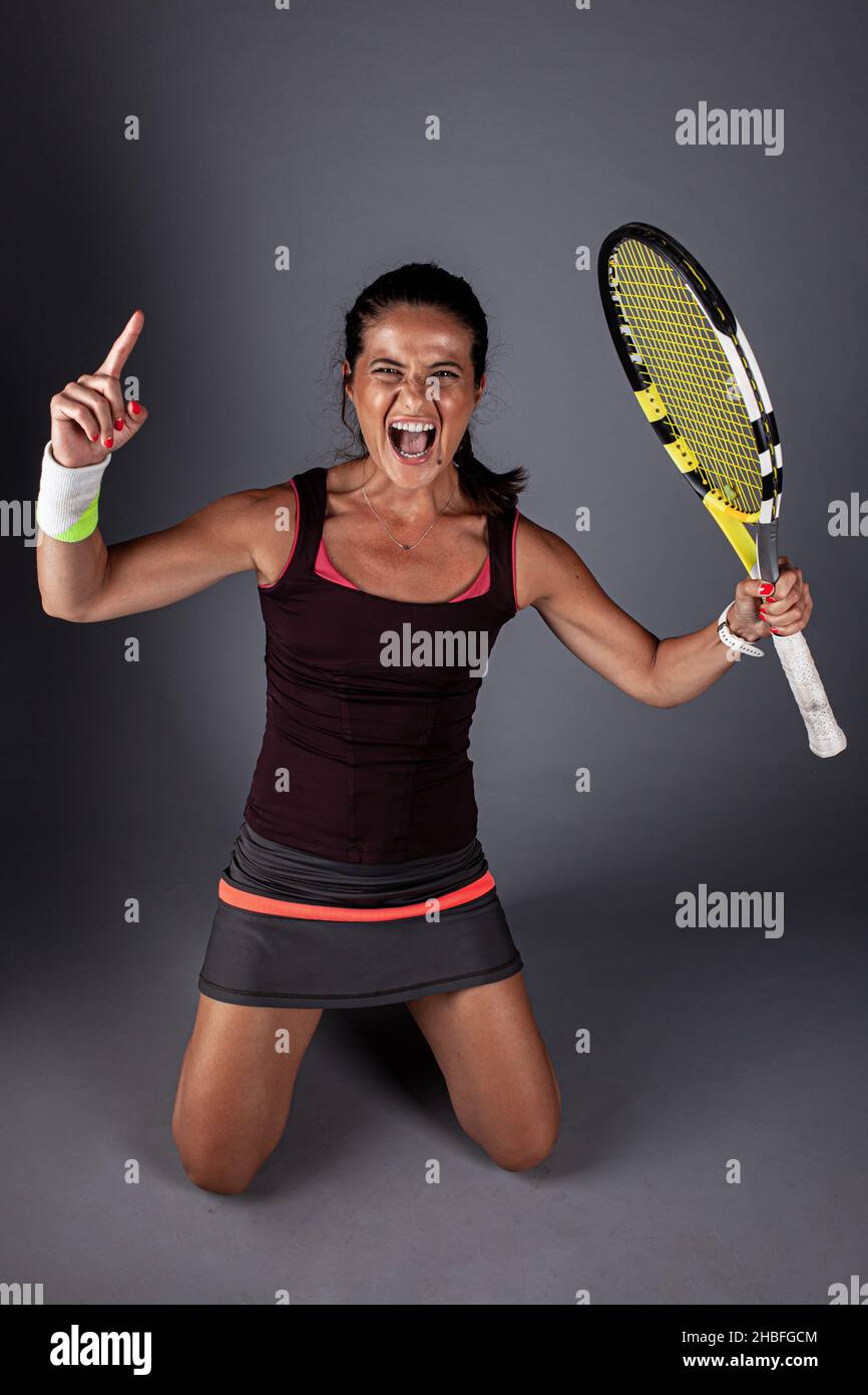 Professional female tennis player. Happy girl screaming with racket in