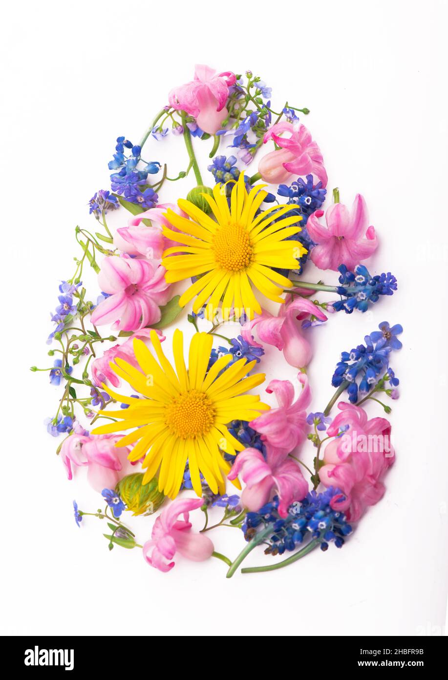 Easter egg shape made of colorful spring flowers and green leaves ...