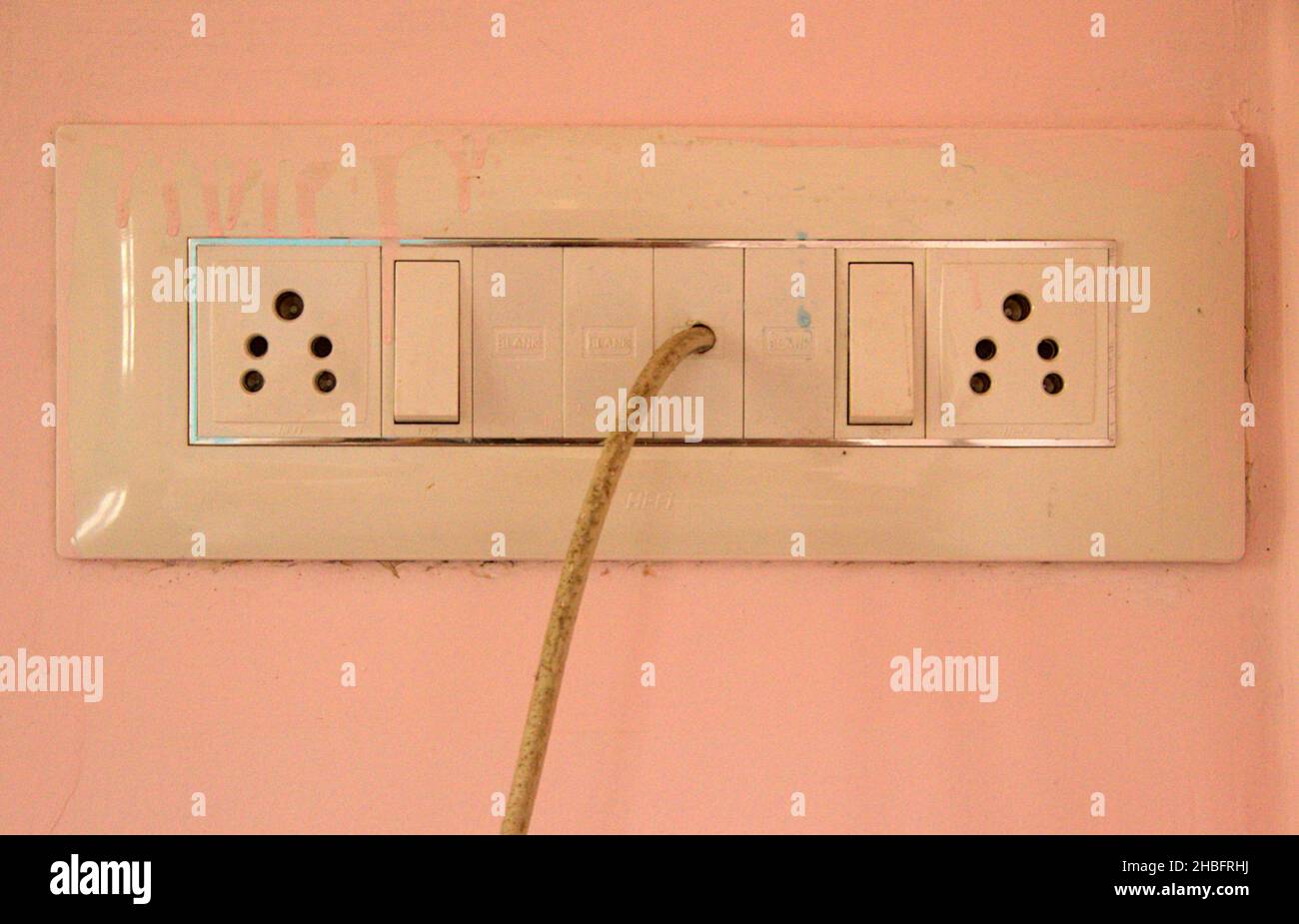 Panel of electric sockets switches on painted wall of house interior Stock Photo