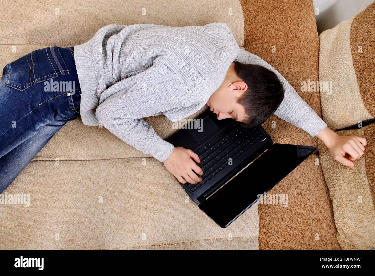 Tired Teenager falling asleep with Laptop on Sofa Stock Photo Alamy