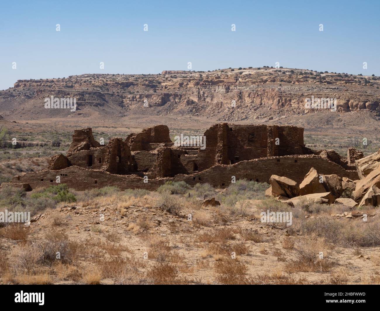 Ruins left by Ancient Puebloans at Chaco Culture National Historic Park in New Mexico with a mountain in the background. Stock Photo
