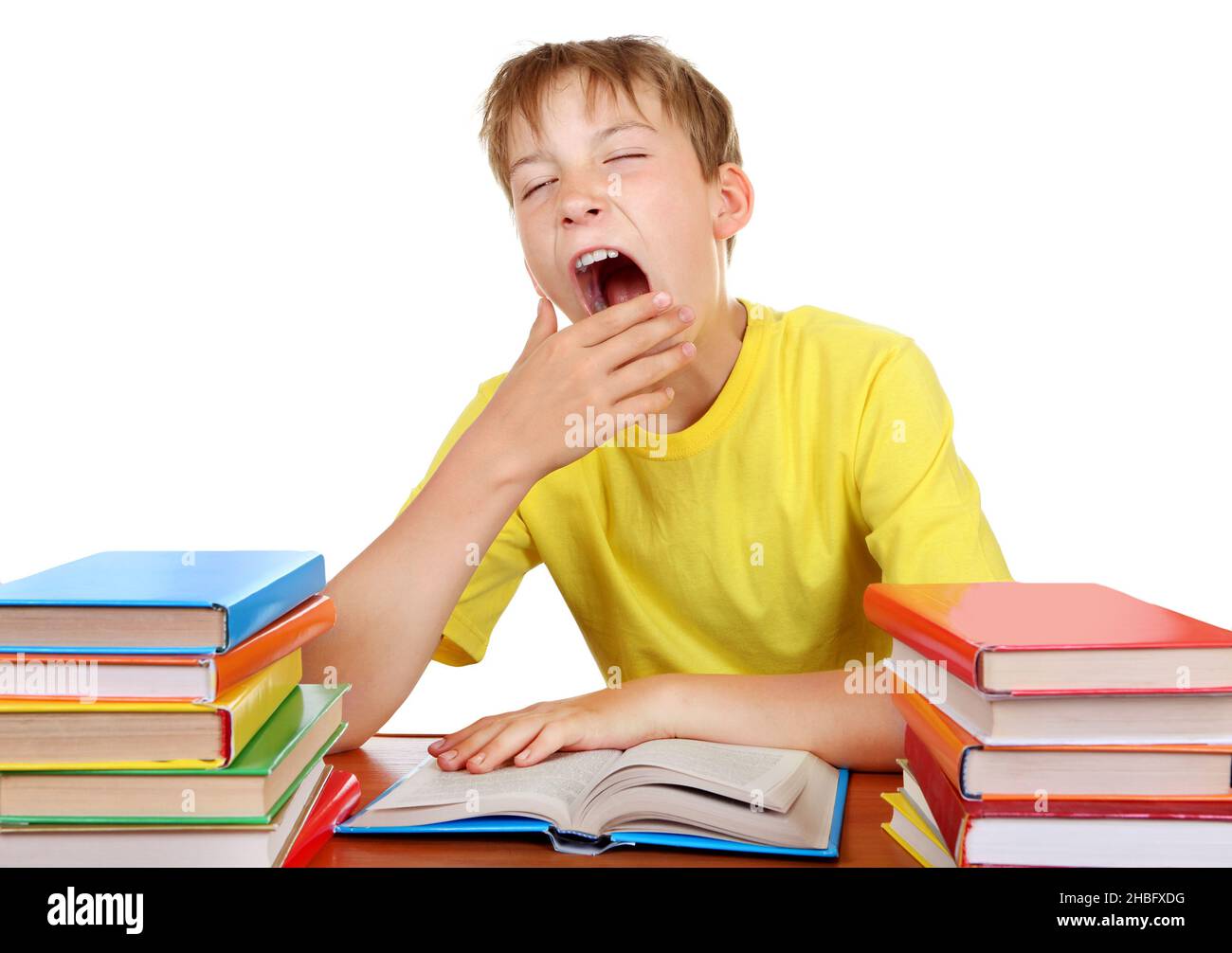 Tired Kid Yawning at the School Desk with a Books on the white background Stock Photo