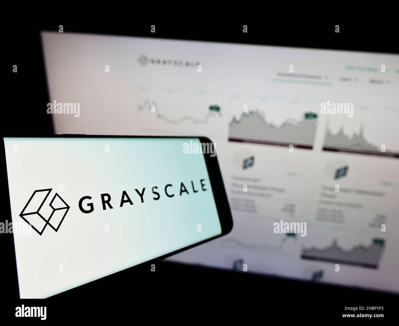 Cellphone with logo of American crypto currency company Grayscale Investments LLC on screen in front of website. Focus on left of phone display. Stock Photo