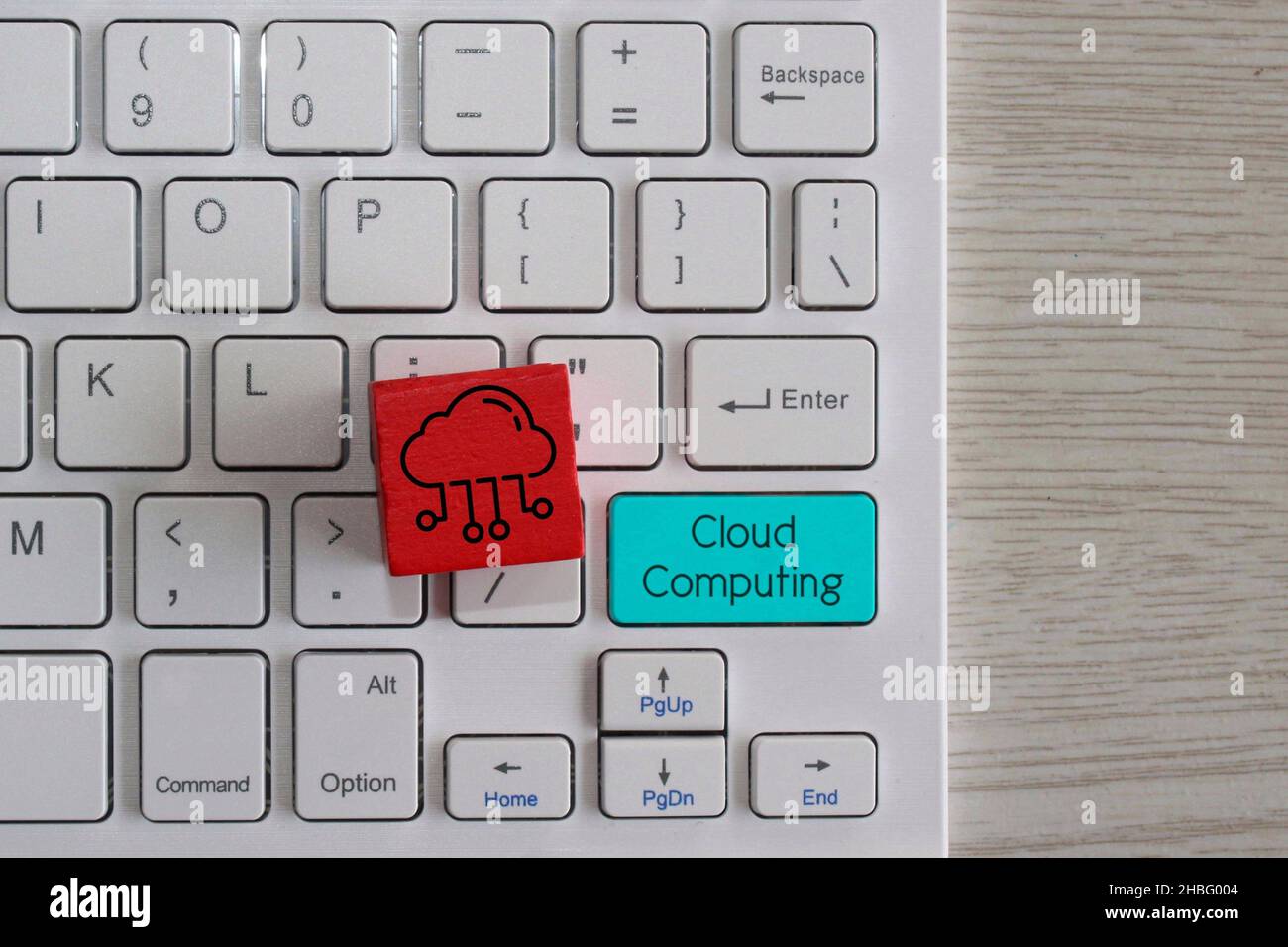 Cloud computing concept. Red wooden cube with cloud icon and keyboard with text Cloud Computing. Stock Photo