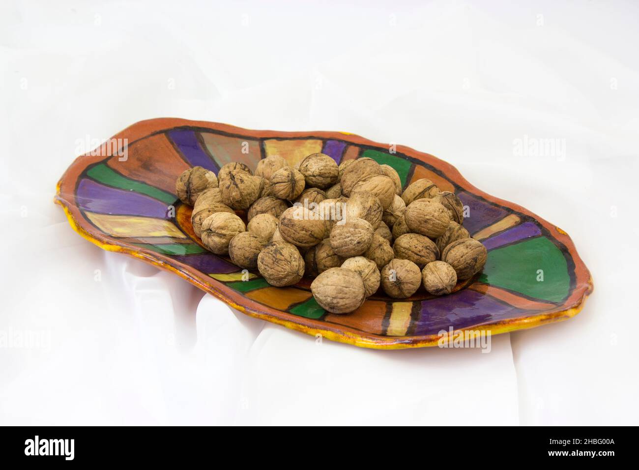 walnuts on a clay plate - white background Stock Photo