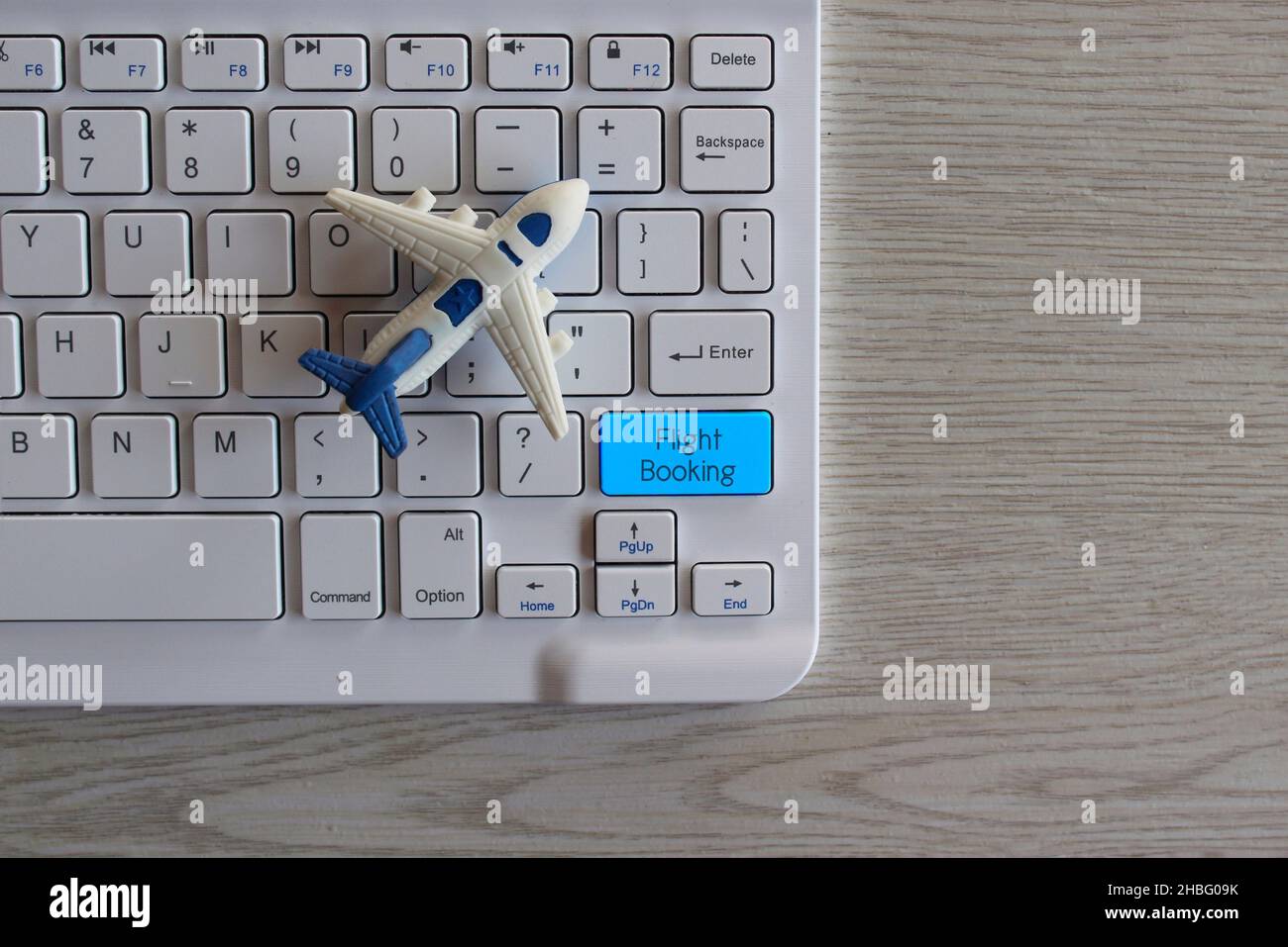 Air Ticket Online Flight Booking Concept. Toy plane and keyboard with text FLIGHT BOOKING. Stock Photo