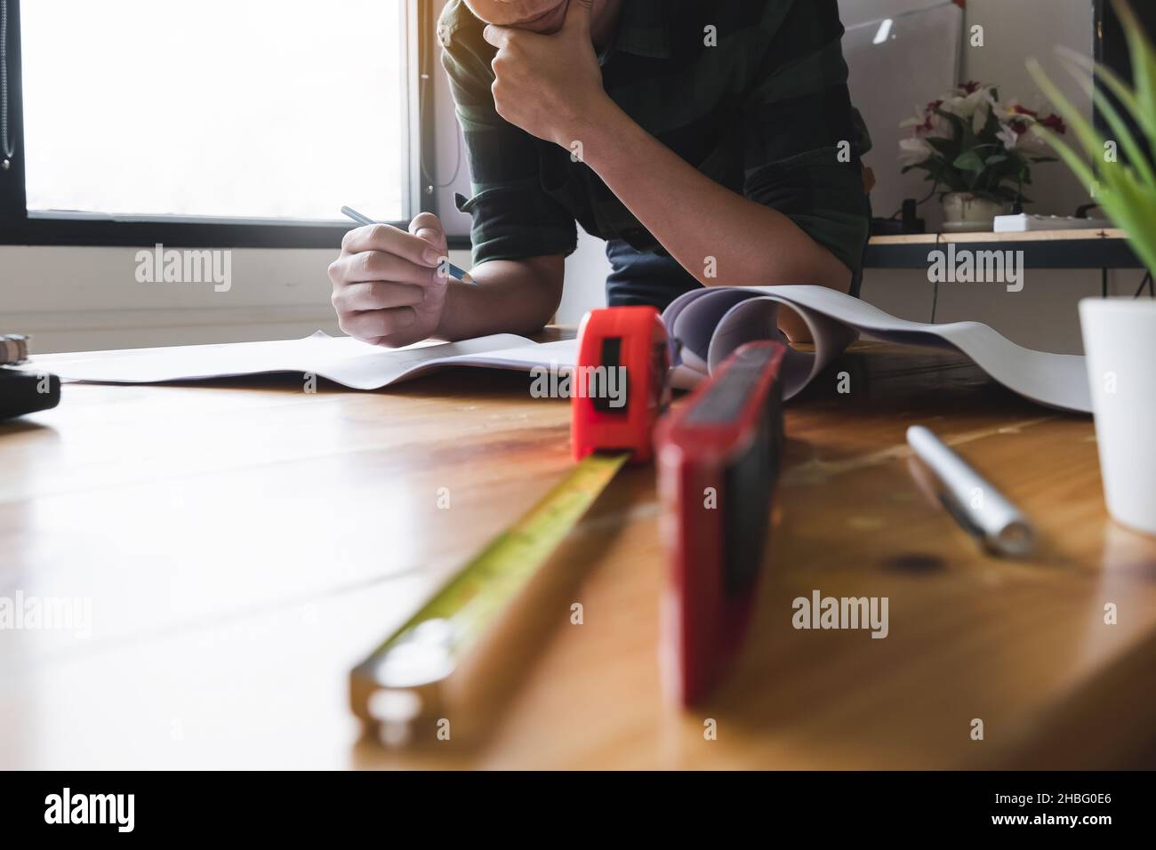 Architect man working with compasses and blueprints for architectural plan,engineer sketching a construction project concept. Stock Photo