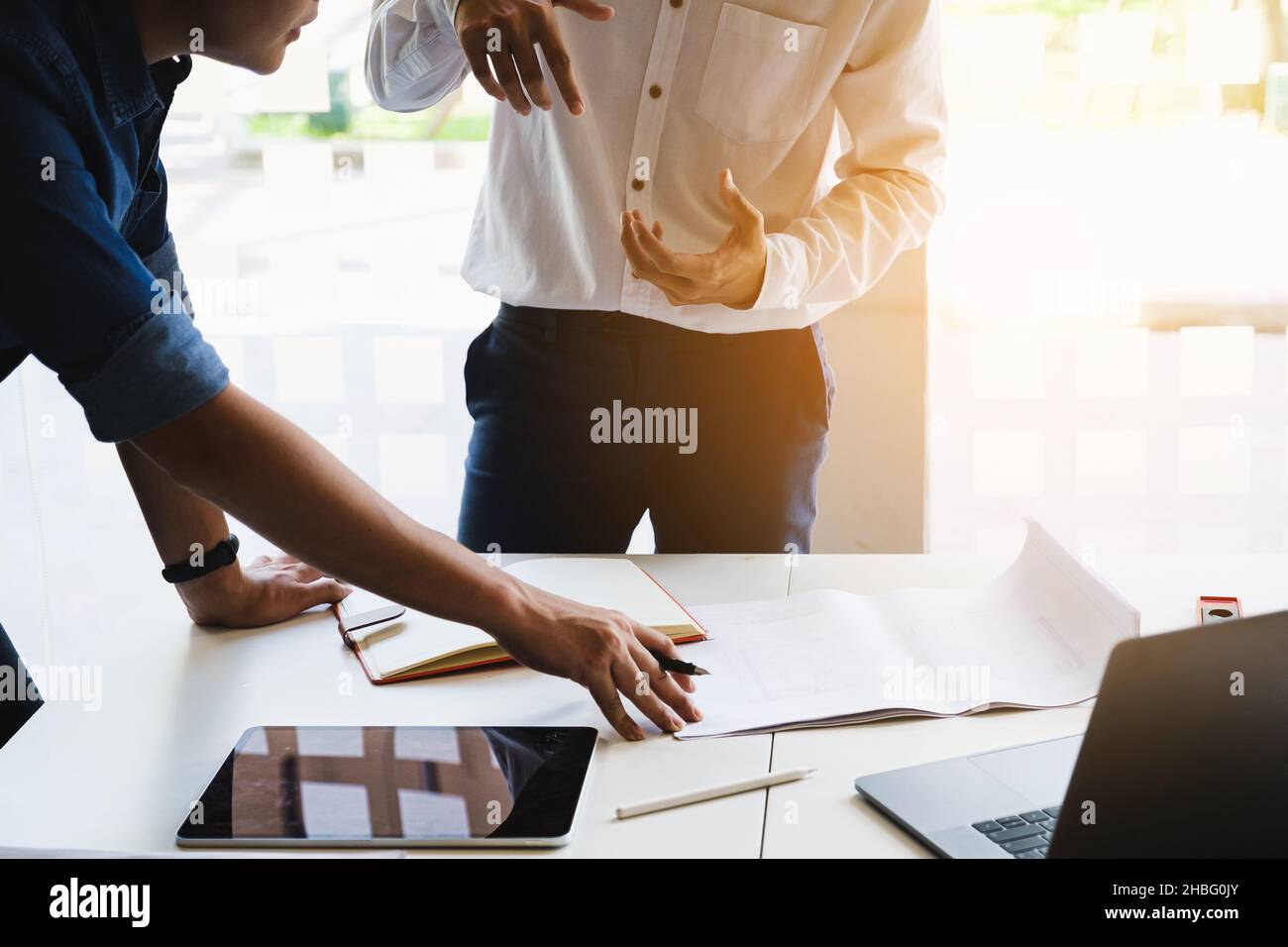 Two Architect man working with compasses and blueprints for architectural plan, engineer sketching a construction project concept. Stock Photo