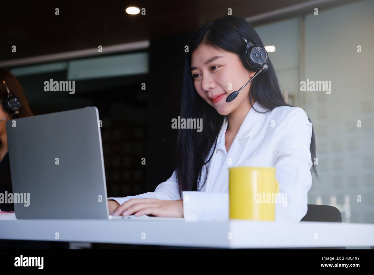 Beautiful business woman or call center workers in headphones for communication and consulting people. Support concept. Stock Photo