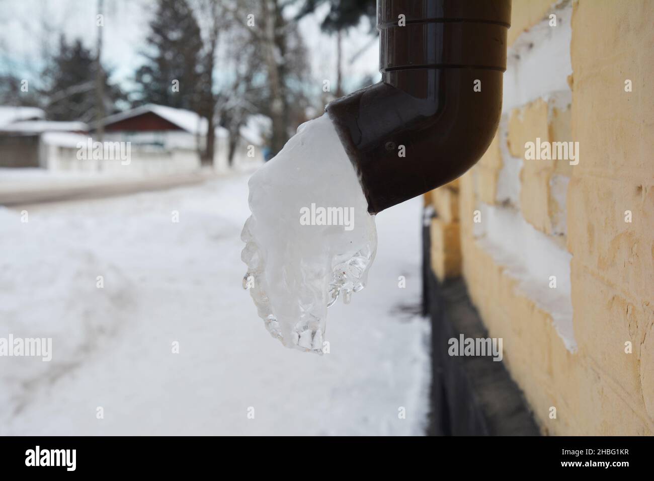 A frozen downpipe, downspout of a rain gutter system. Ice or frozen