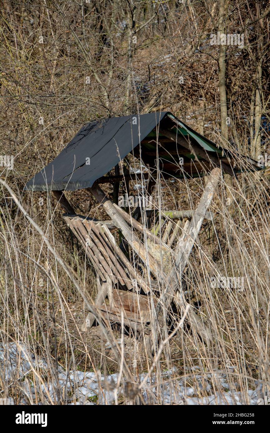 Wooden wild animals feeder in the forest. Deer manger in the winter. Stock Photo