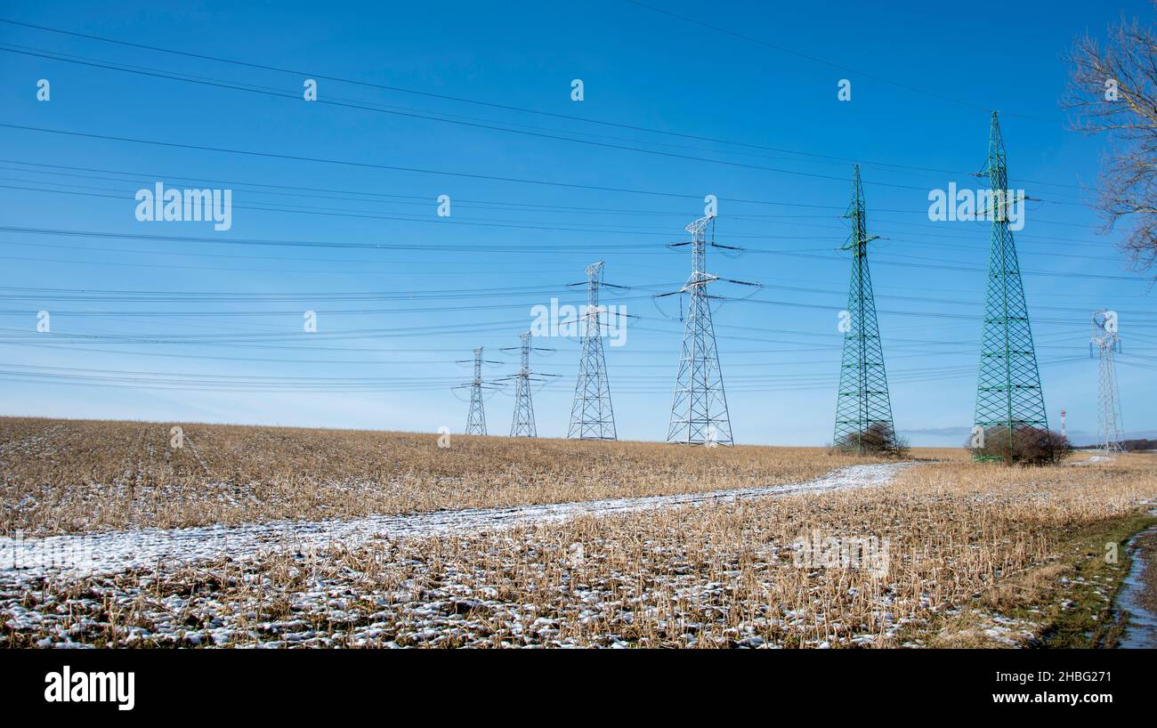 High voltage power lines and power pylons in the agricultural field ...